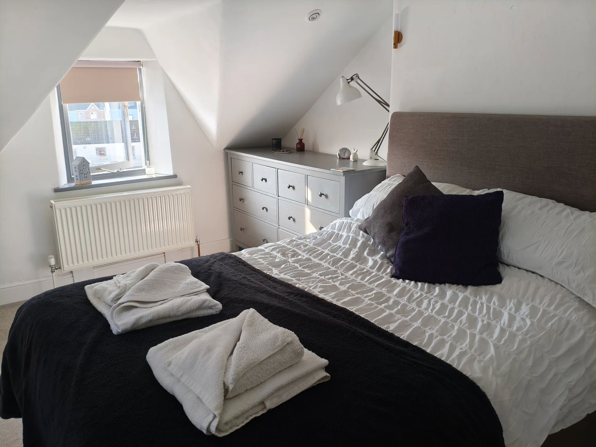 Master bedroom with fresh towels laid out on the bed