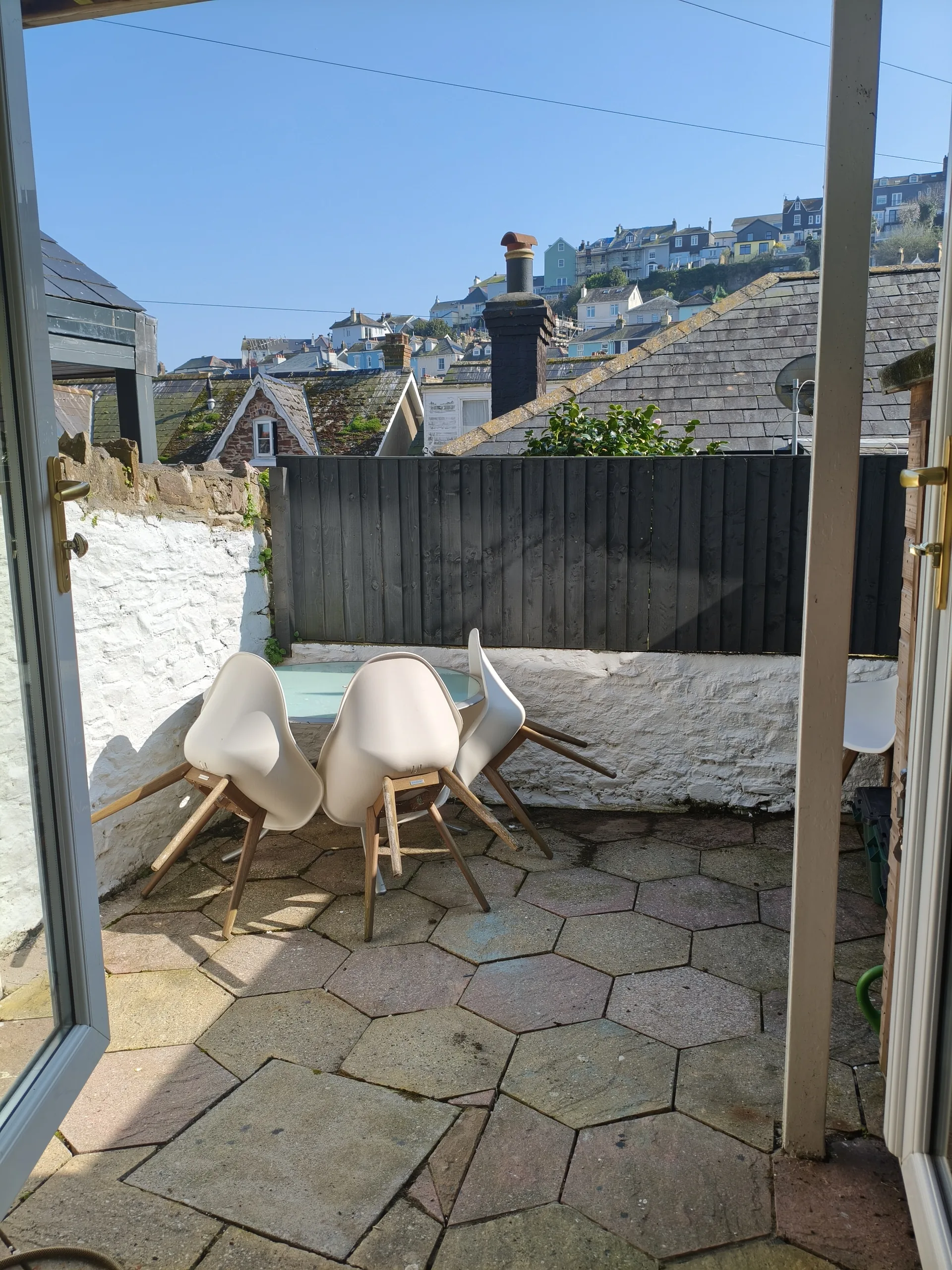 Courtyard with chairs viewed from the kitchen doorway, Dartmouth hillside behind