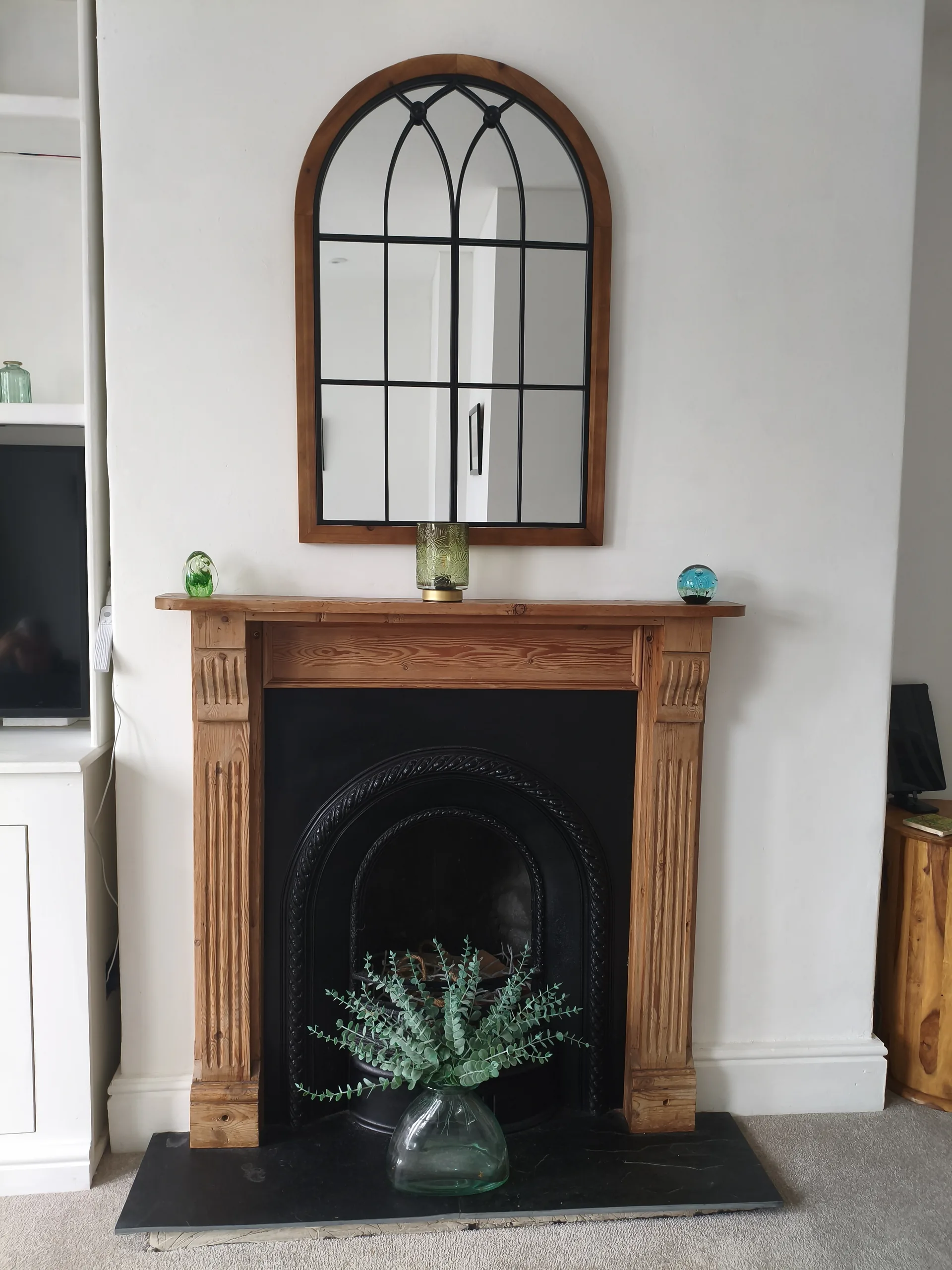 Victorian cast-iron fireplace with pine surround and arched mirror